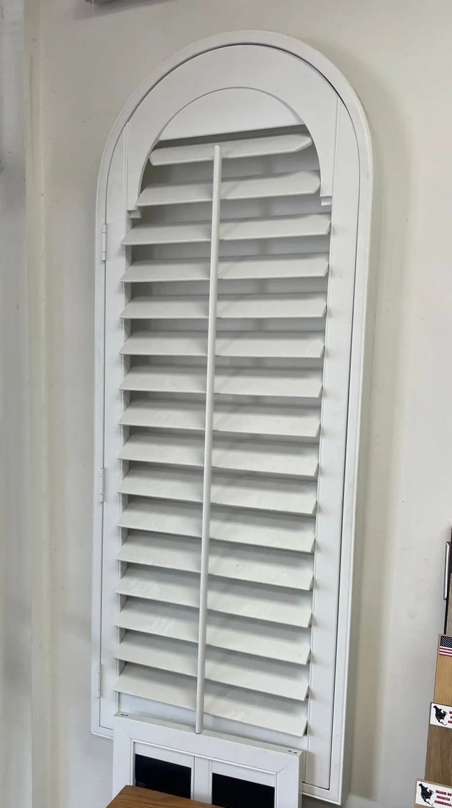 White arched plantation shutter in the Angelo's showroom